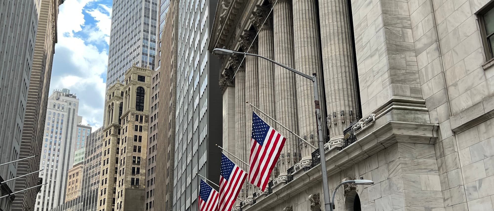 The New York Stock Exchange building facade with Corinthian columns and American flags